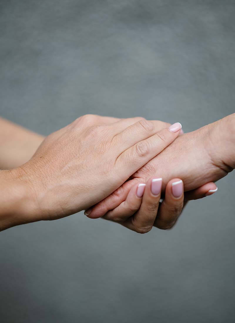 dos manos sujetando la mano de otra persona